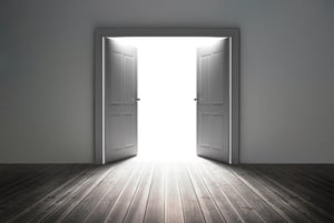 Doorway revealing bright light in dull grey room