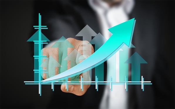 a businessman is using a touchscreen that shows an upward trending graph
