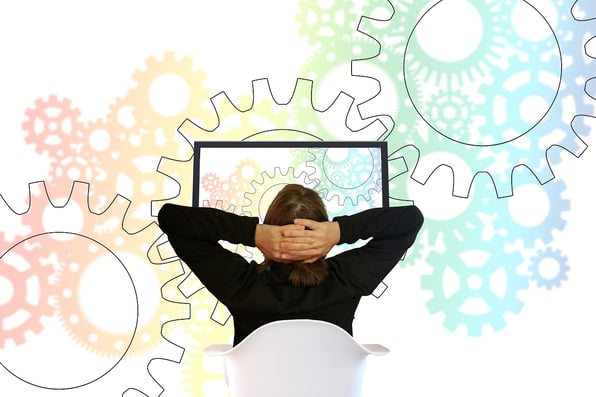 a man looking at a computer screen with gears in the background