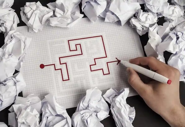 A hand trying to complete a maze puzzle
